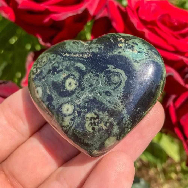 Polished Kambaba Jasper heart featuring deep green and black stromatolite orbs for grounding and Heart Chakra healing.