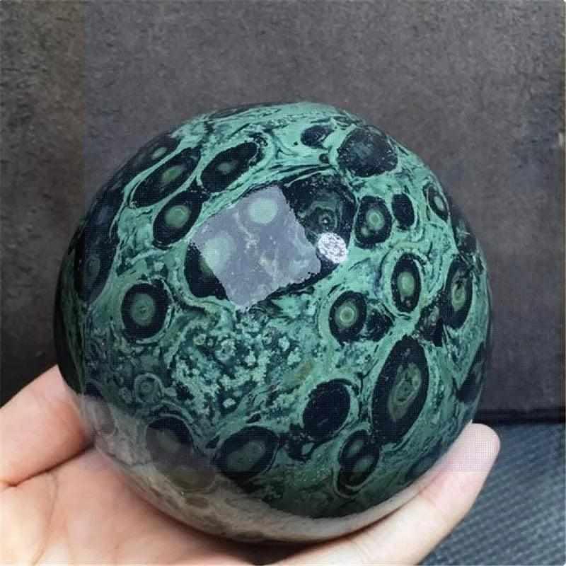 Polished Kambaba Jasper sphere featuring deep green and black orb patterns for grounding, meditation, and chakra healing.