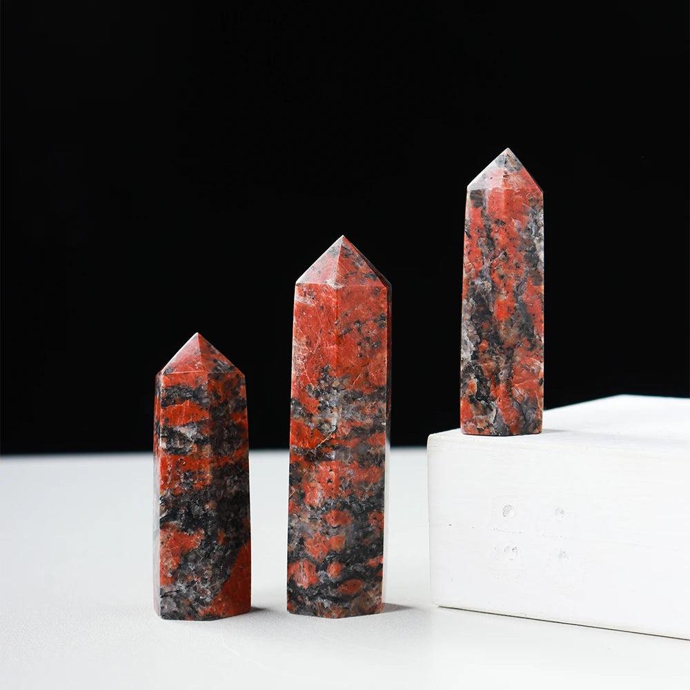 Three red and black Katophorite crystal towers, hexagonal obelisk wands for energy healing and home decor.