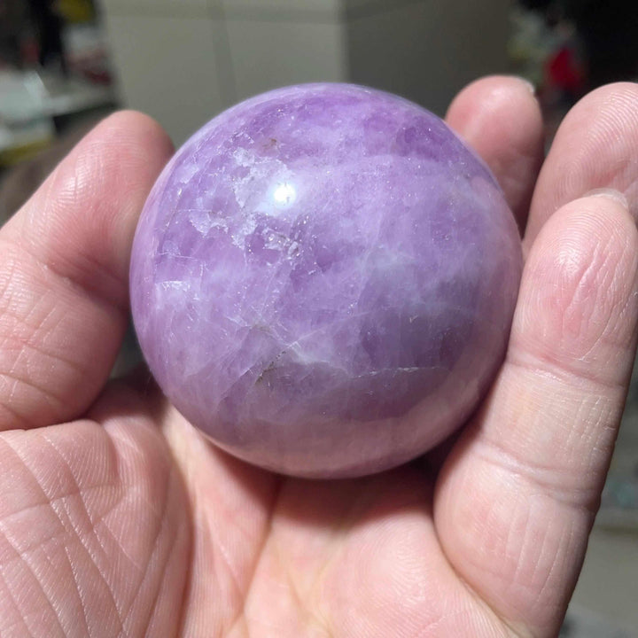 Polished Kunzite sphere in soft pink and lilac, a natural heart-centered crystal for emotional calm and gentle love.