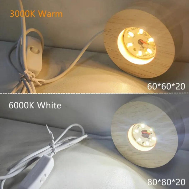 Two round wooden LED light bases, one glowing warm 3000K and the other cool 6000K white, with USB cords.