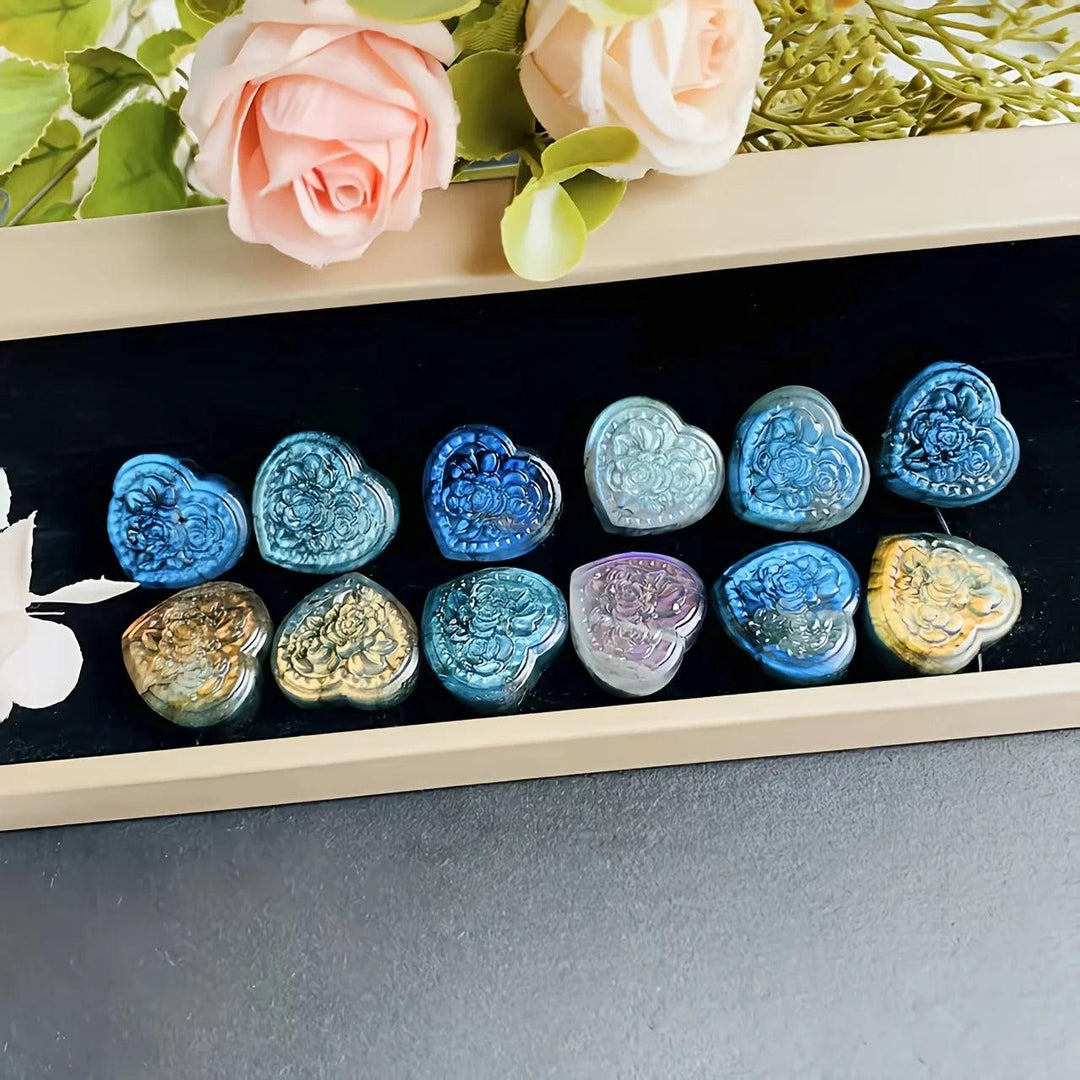 Polished Labradorite crystal heart pendants with intricate floral carvings, showcasing iridescent blue and gold flashes.