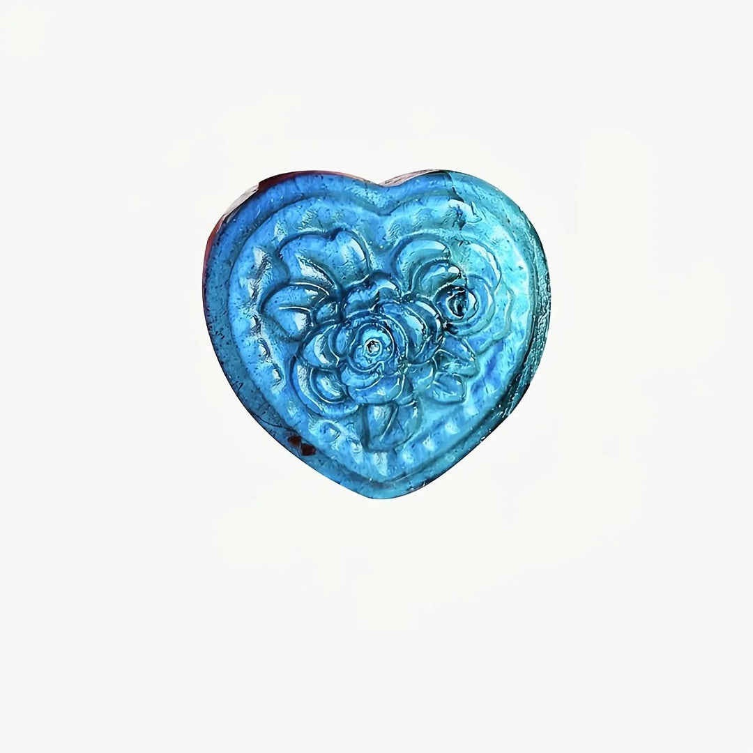 Polished Labradorite heart pendant with floral carving, featuring iridescent blue flashes for intuition and protection.