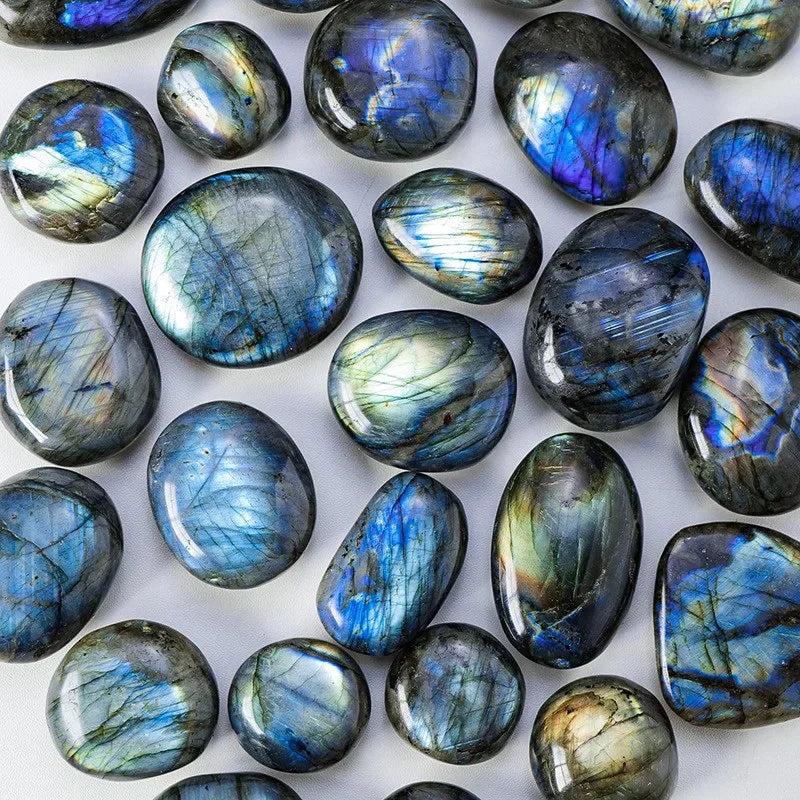 Polished blue labradorite palm stones with shimmering iridescent flashes for healing and decor.