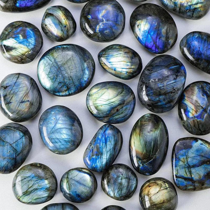 Polished blue labradorite palm stones with shimmering iridescent flashes for healing and decor.