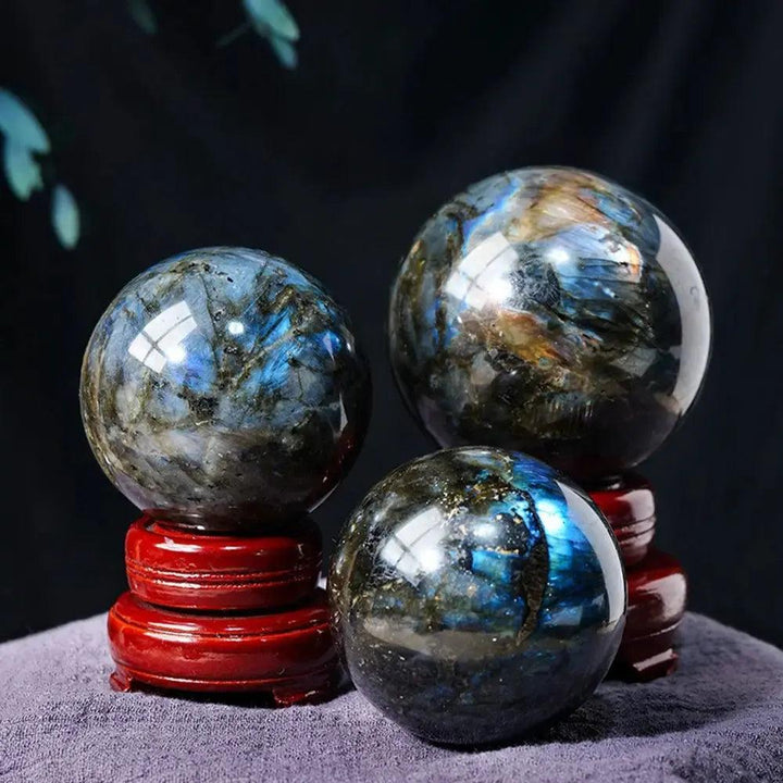 Three polished Labradorite crystal spheres with blue, green, and gold flashes, radiating mystical energy from Crystal Destiny.