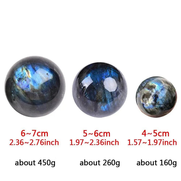 Three polished Labradorite crystal spheres of varying sizes, displaying iridescent blue and green flashes.