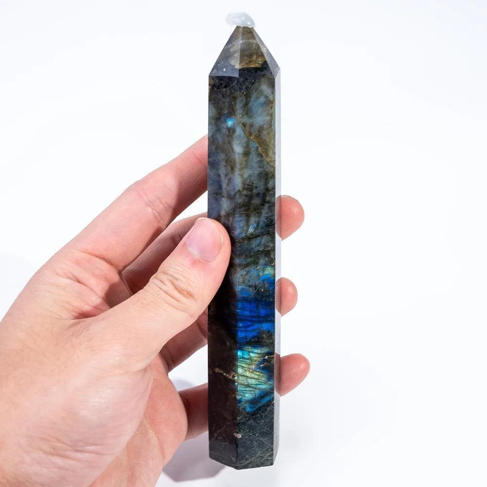 Hand holding a polished Labradorite Crystal Tower, showcasing vivid blue, gold, and green labradorescence for protection and growth.