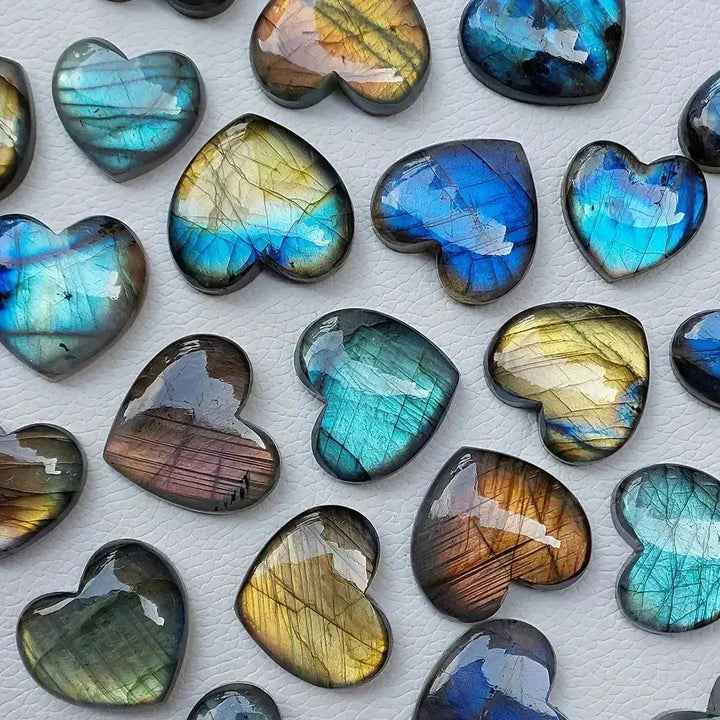 Labradorite heart carvings by Crystal Destiny, showcasing iridescent blue, gold, and green flashes.