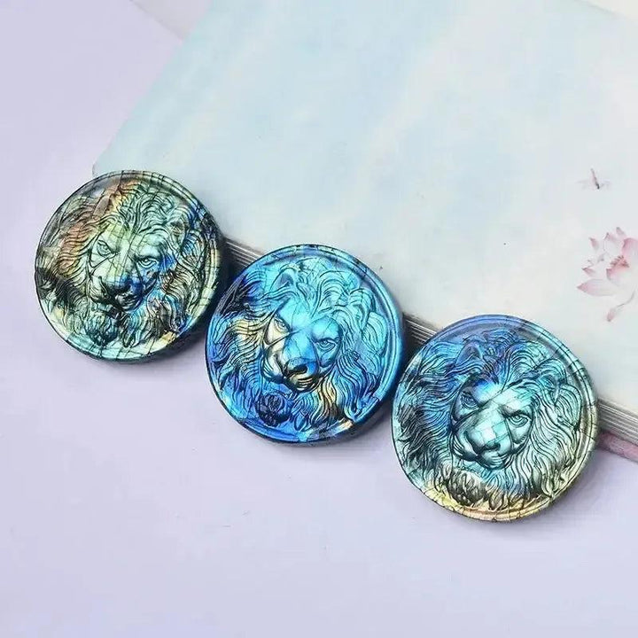 Three iridescent Labradorite lion carvings in blue, green, and gold for Growth & Transformation.