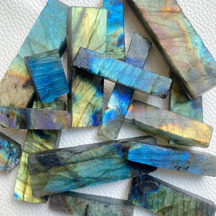 Raw labradorite crystal sticks featuring vibrant blue, gold, and green spectral flashes for Third Eye Chakra healing.