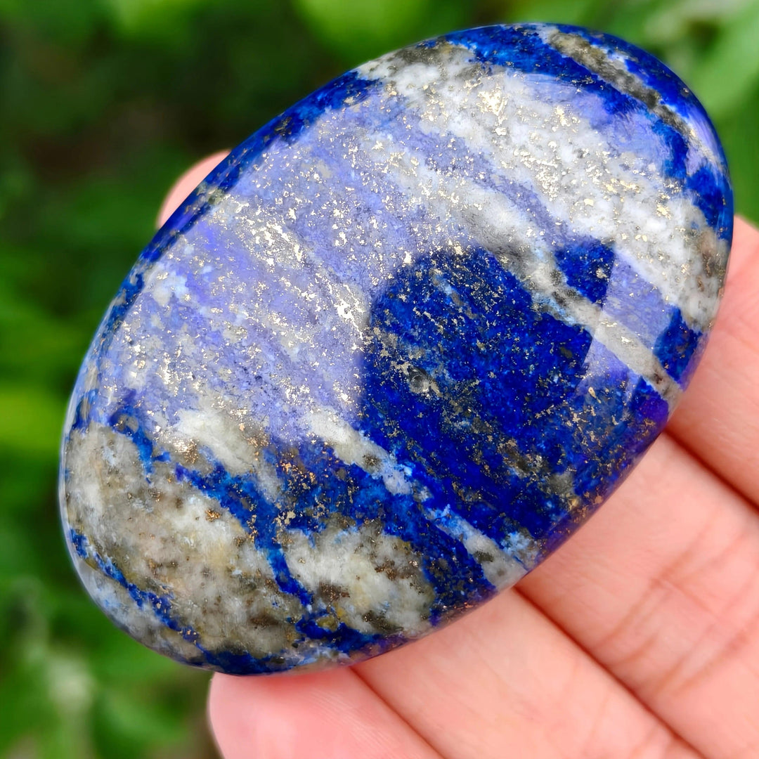 Polished Lapis Lazuli Crystal Palm Stone with deep blue hues, golden pyrite flecks, and white calcite veining.