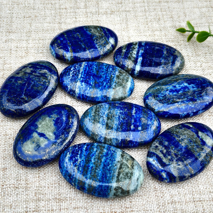 Polished Lapis Lazuli Crystal Palm Stones with deep blue hues and golden pyrite flecks for Third Eye healing.