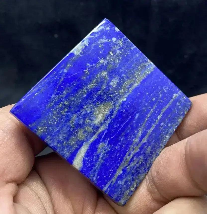 AAA-grade Natural Lapis Lazuli Crystal Pyramid, deep royal blue with golden pyrite flecks, held in hand.