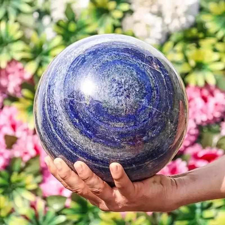Polished Lapis Lazuli crystal sphere in deep royal blue with gold pyrite flecks, perfect for meditation and intuition.