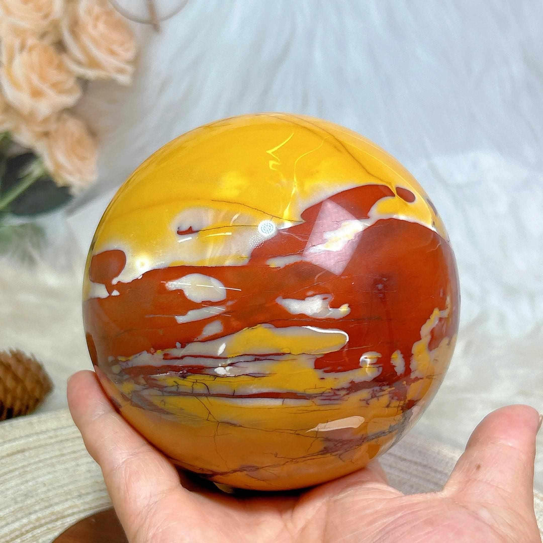Large Mookaite sphere with stand, featuring polished red, yellow, and cream swirls for grounding and chakra healing.