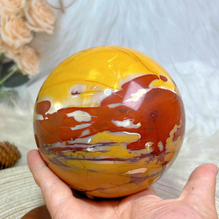 Large Mookaite sphere with stand, featuring polished red, yellow, and cream swirls for grounding and chakra healing.