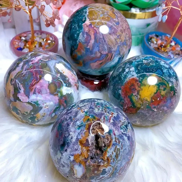 Large Ocean Jasper spheres featuring swirling green, pink, and blue orbs to promote calm and emotional healing.