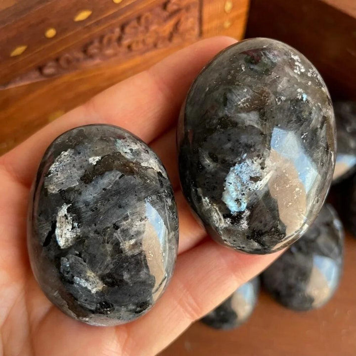 Polished grey Larvikite palm stones with blue flash, a healing crystal home decoration.