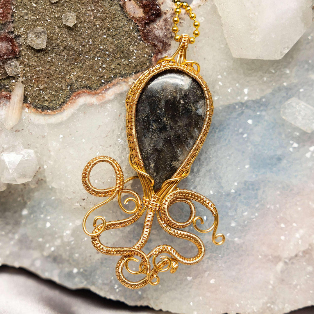 Larvikite Calamari Wire Wrap Pendant: Dark grey Larvikite crystal in a handcrafted gold copper wire squid design.