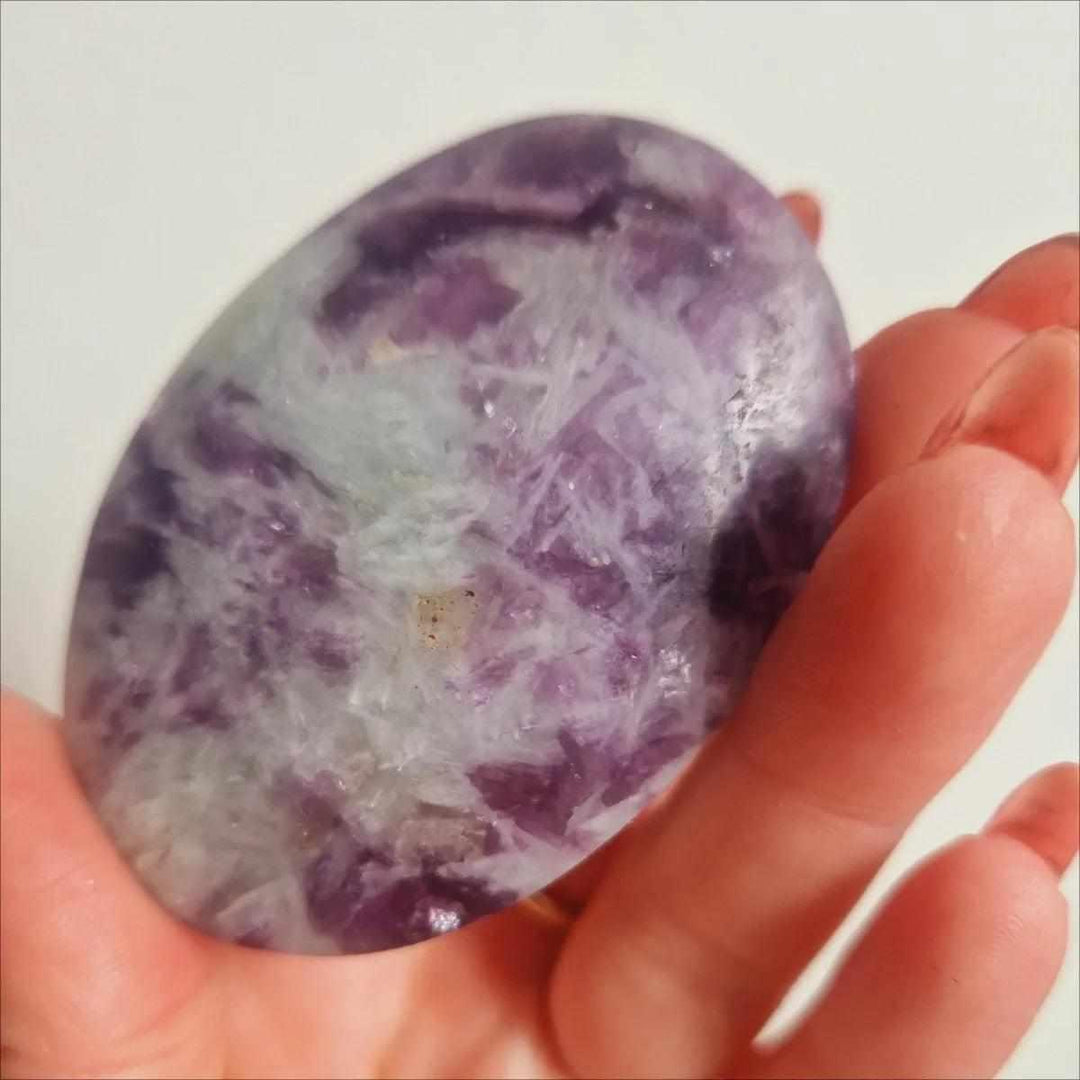 Smooth lavender Lepidolite palm stone with shimmering mica flecks, perfect for calming meditation and emotional balance.