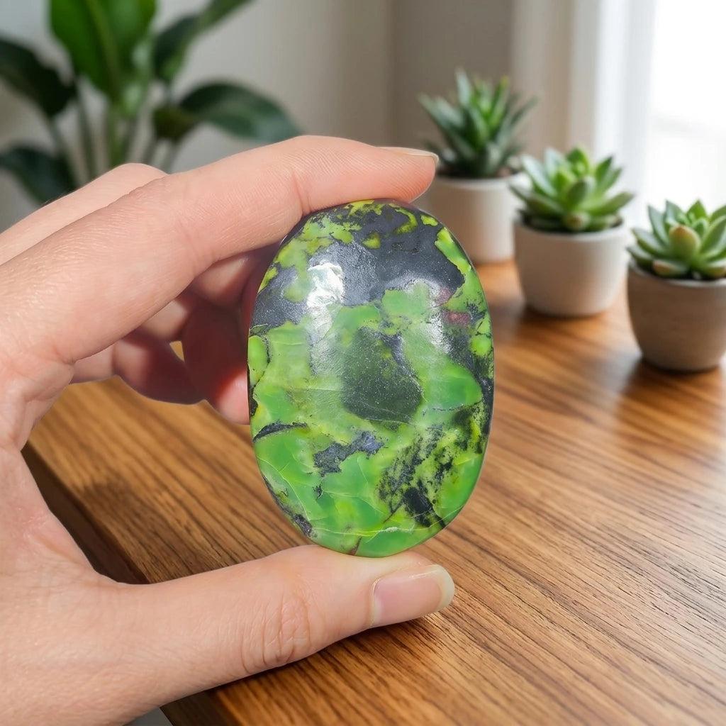 Polished Lizardite palm stone with vibrant green and black patterns for grounding and heart-centered healing.