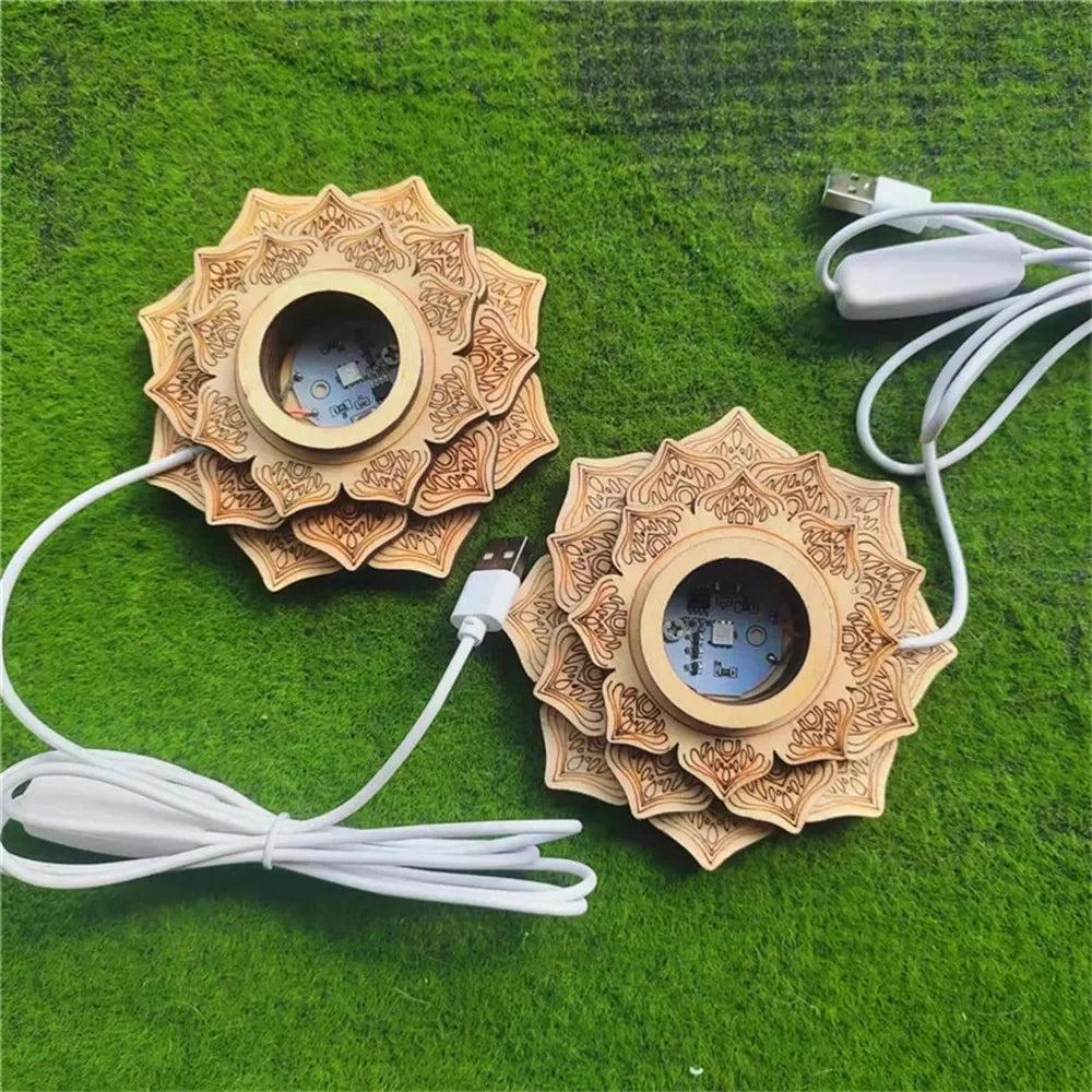 Two natural wood lotus LED crystal ball stands with intricate carvings and USB cables on a green surface.