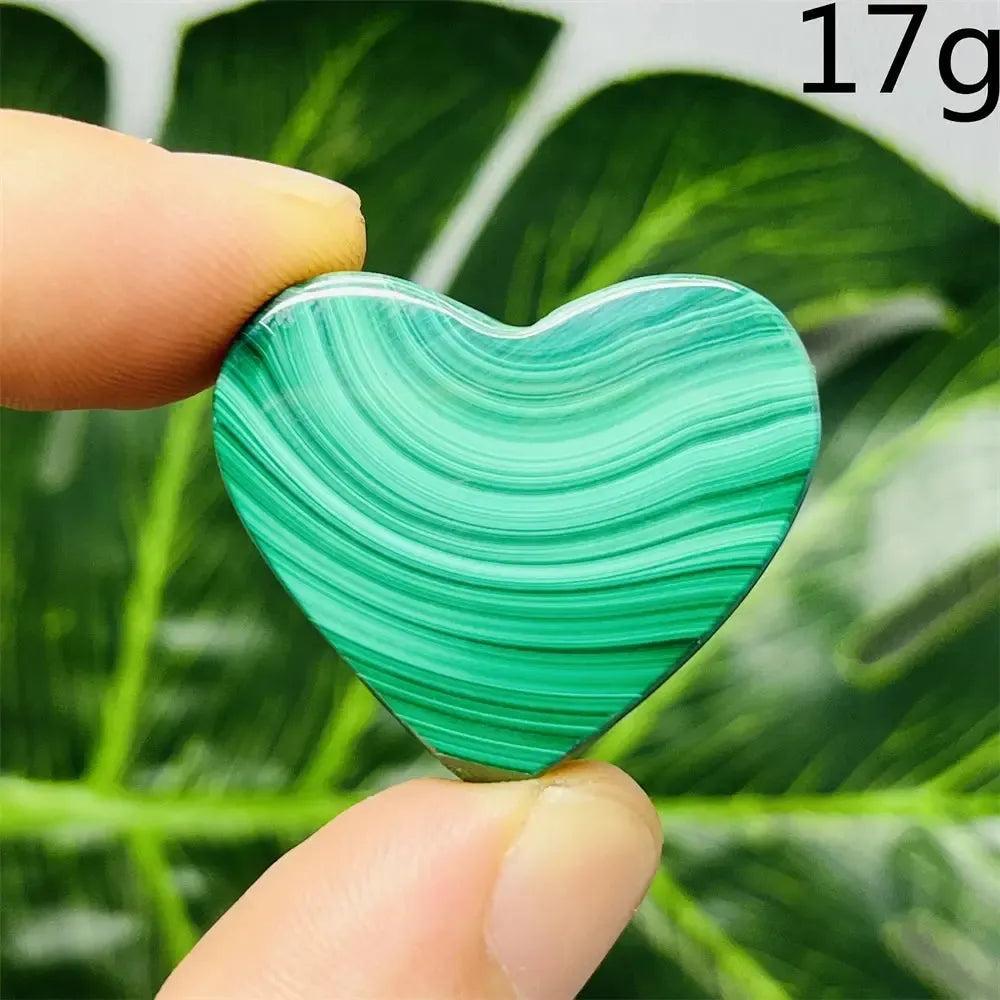 Malachite Crystal Heart: Handcrafted, polished deep forest green heart with mesmerizing bands, held between fingers.