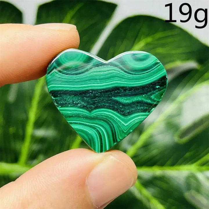 Malachite Crystal Heart: Polished deep forest green heart with mesmerizing bands, held between fingers.