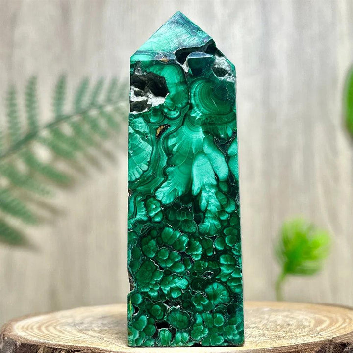 Polished Malachite crystal obelisk tower featuring deep green banded patterns for heart chakra healing and energy work.