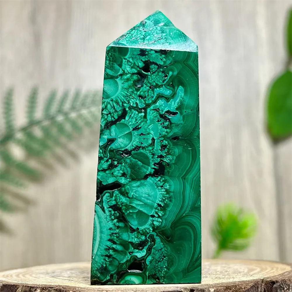 Polished Malachite crystal obelisk tower featuring deep green banded patterns for heart chakra healing and transformation.