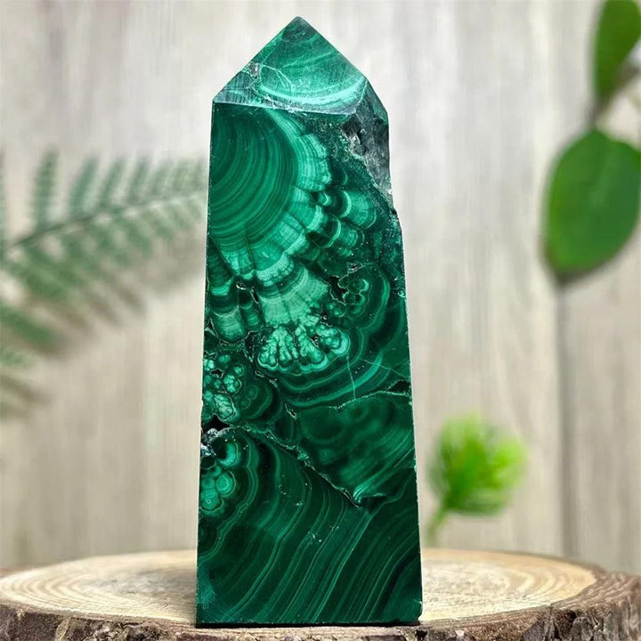 Polished Malachite crystal obelisk tower featuring vibrant, deep green banded patterns for heart chakra healing.