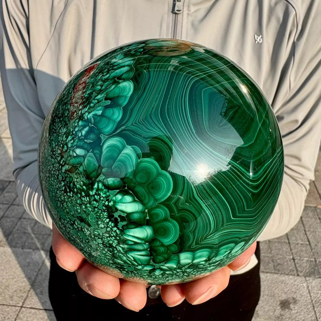 Polished Malachite crystal sphere featuring vivid forest green banded patterns for heart chakra healing and energy.