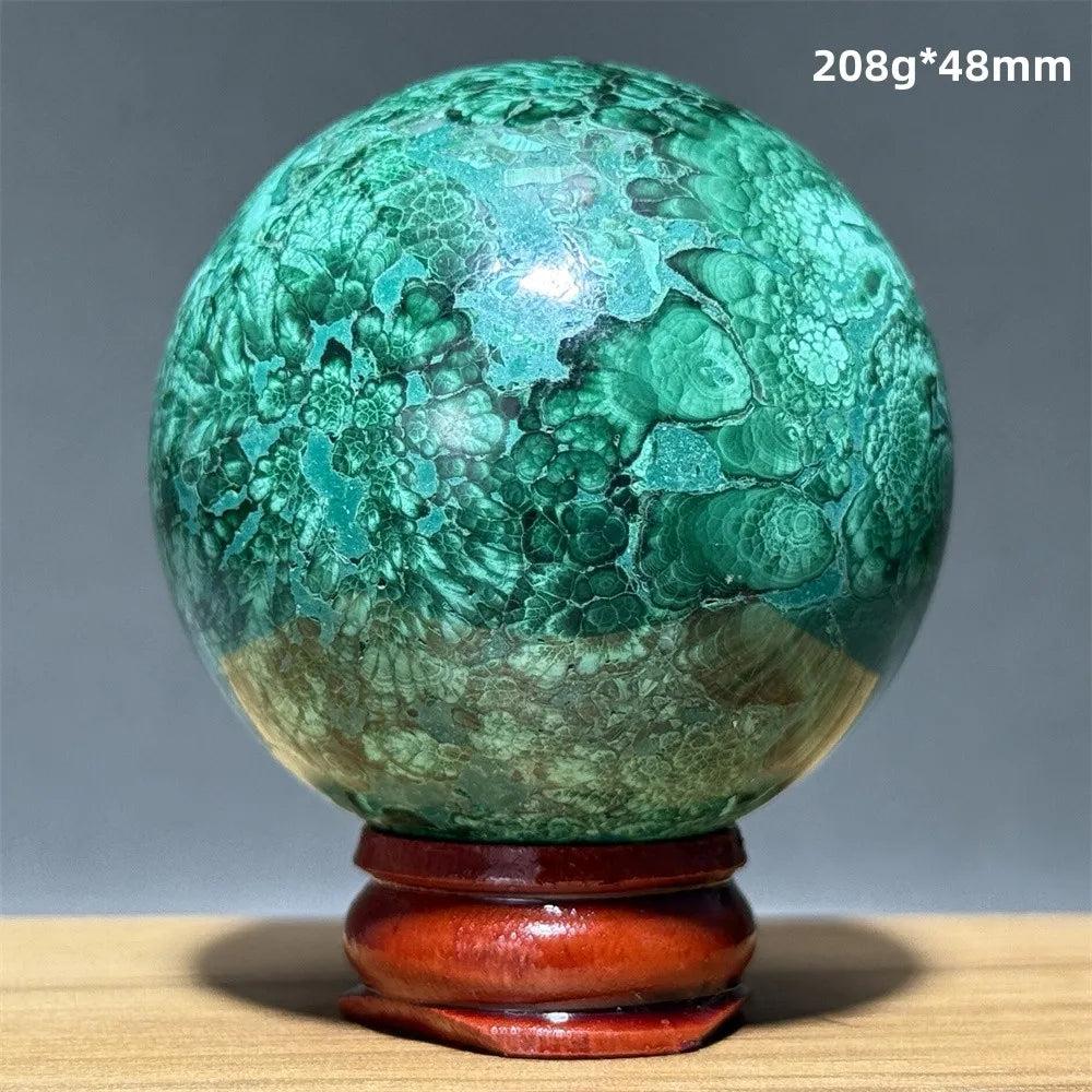 Polished 48mm malachite crystal sphere featuring vivid green banded patterns on a wooden display base for healing.