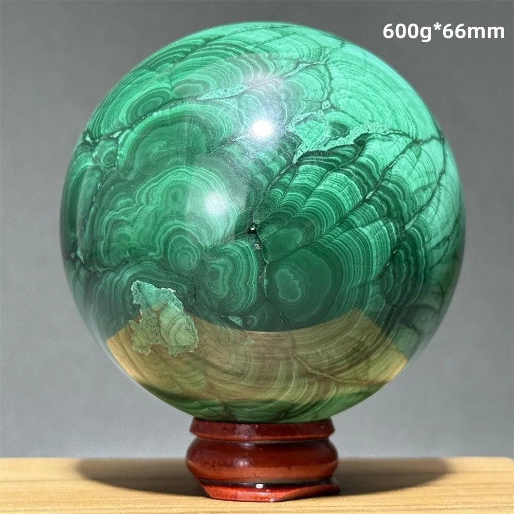 Polished 66mm Malachite crystal sphere featuring vibrant green banded patterns on a wooden display base for healing.