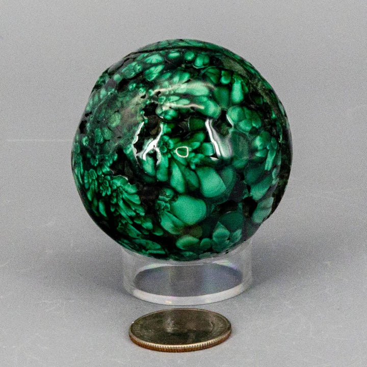 Malachite Sphere: a polished, deep forest green and mint crystal with unique swirling bands, radiating protective energy.