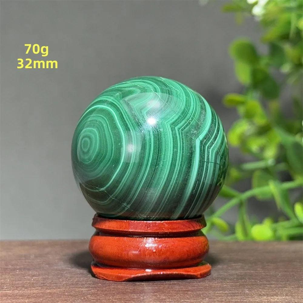 Polished 32mm Malachite crystal sphere featuring vibrant green concentric banding on a wooden display base for healing.