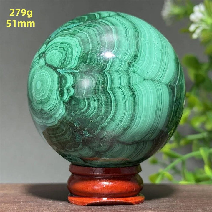 51mm AAAAA Malachite crystal sphere featuring deep green concentric banding for transformation, set on a display base.