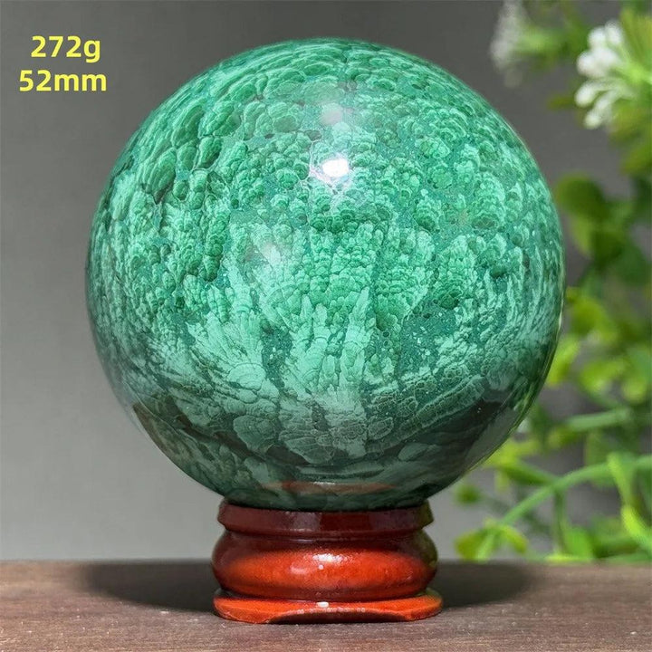 52mm Malachite crystal sphere with vibrant green banded patterns and a wooden display base for healing and transformation.