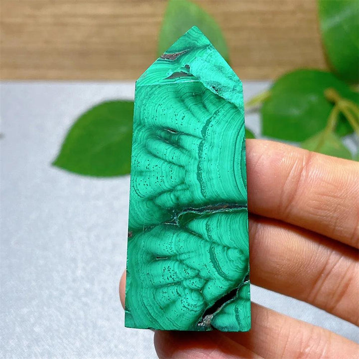 Polished Malachite crystal tower featuring vibrant green banded patterns for healing, transformation, and energy work.