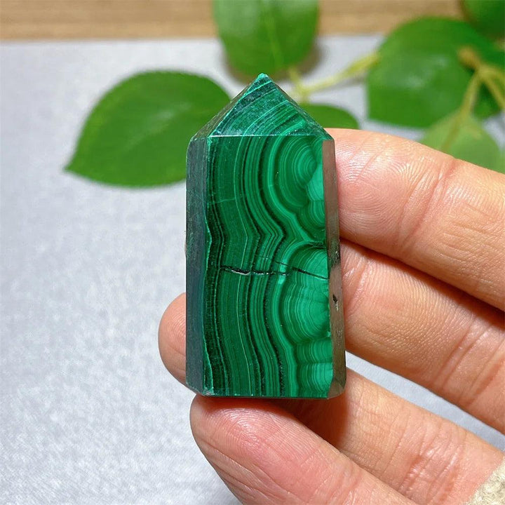 Polished Malachite crystal tower featuring vibrant green banded patterns for healing, growth, and transformation.