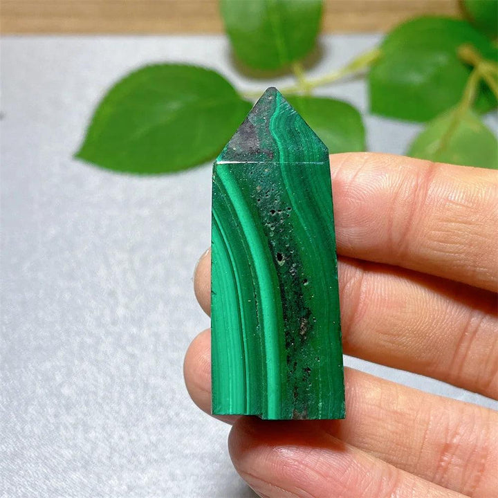 Polished Malachite crystal tower with vibrant green banded patterns for heart chakra healing and transformation.