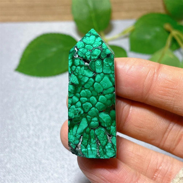 Polished Malachite crystal tower featuring vibrant green banded patterns for healing, growth, and transformation.