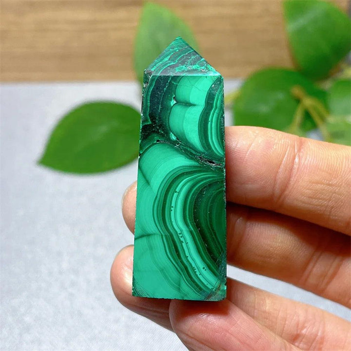 Polished Malachite crystal tower featuring vibrant green banded patterns for healing, growth, and transformation.