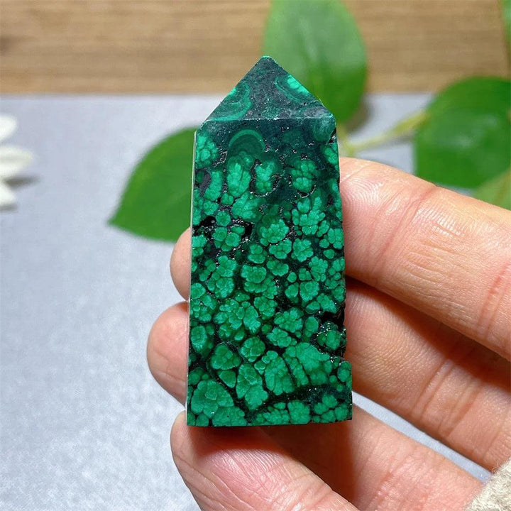 Polished Malachite crystal tower featuring vibrant green banded patterns for transformation and heart chakra healing.