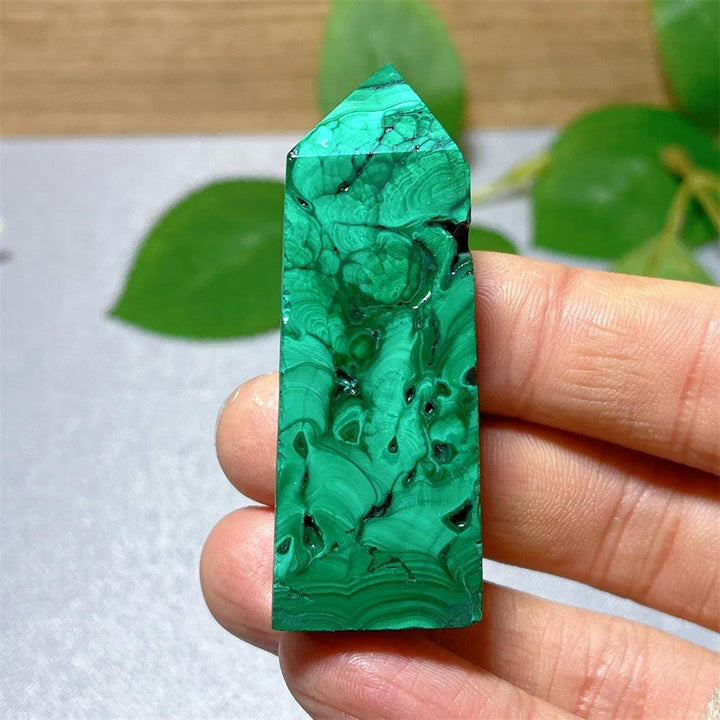 Polished Malachite crystal tower with vibrant green banded patterns, perfect for heart chakra healing and transformation.