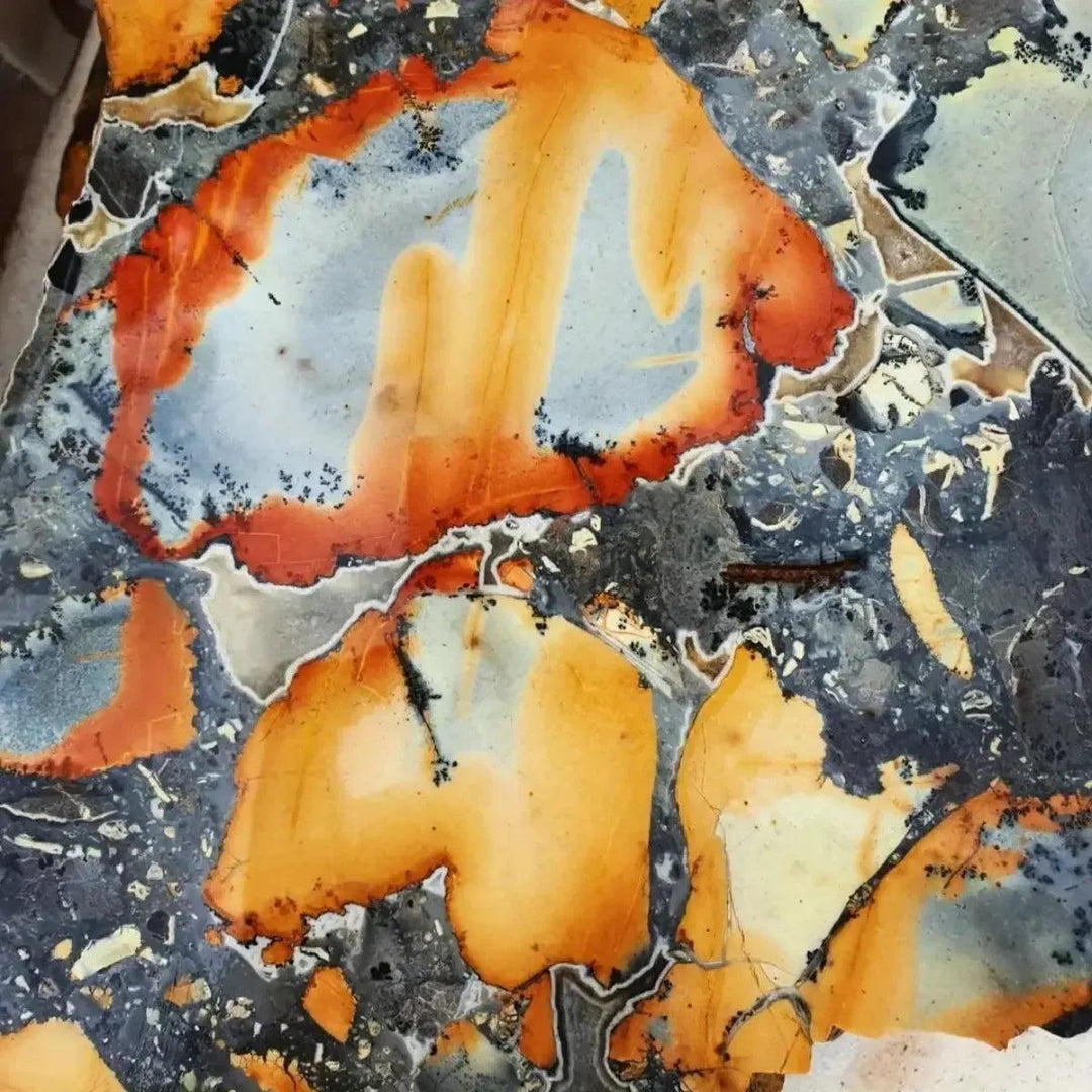 Maligano Jasper Crystal Destiny slab with swirling yellow, black, white, and orange patterns, promoting clarity and focus.