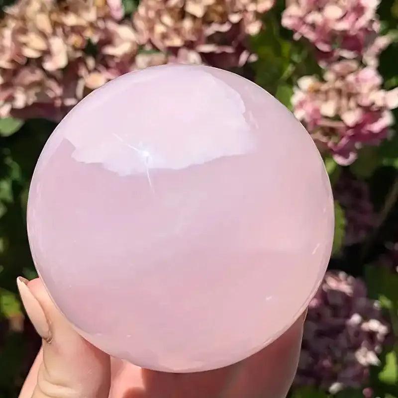 Polished pastel pink Mangano Calcite sphere for Heart chakra healing, radiating soft, compassionate energy.