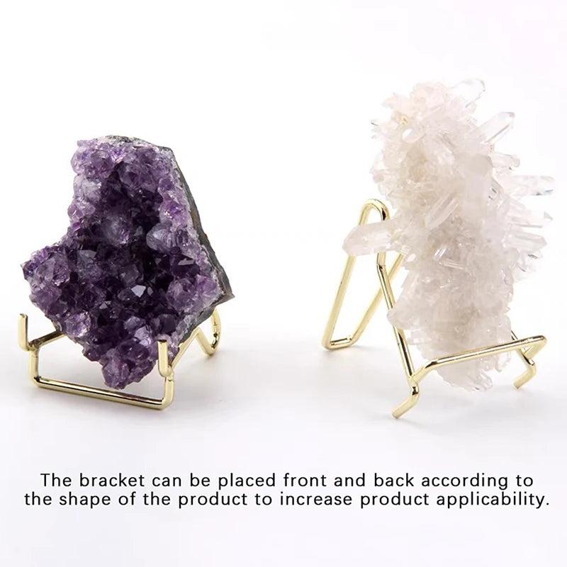 Gold metal arm easels displaying a purple amethyst geode and a white clear quartz crystal cluster.