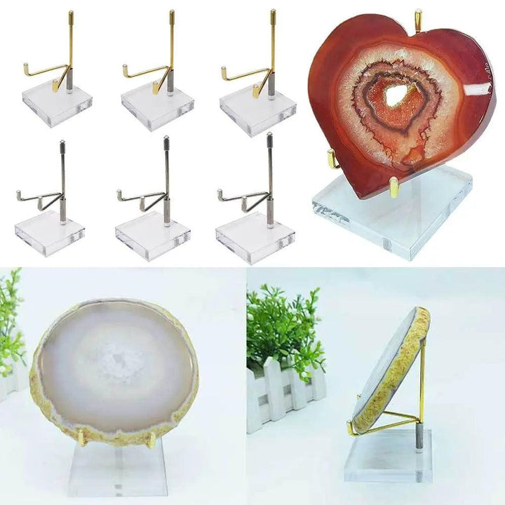 Gold and silver metal display stands with clear acrylic bases holding a red heart-shaped agate and a round white agate.